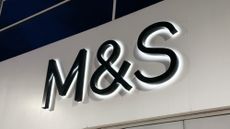 The M&S logo on the wall above a store entrance.