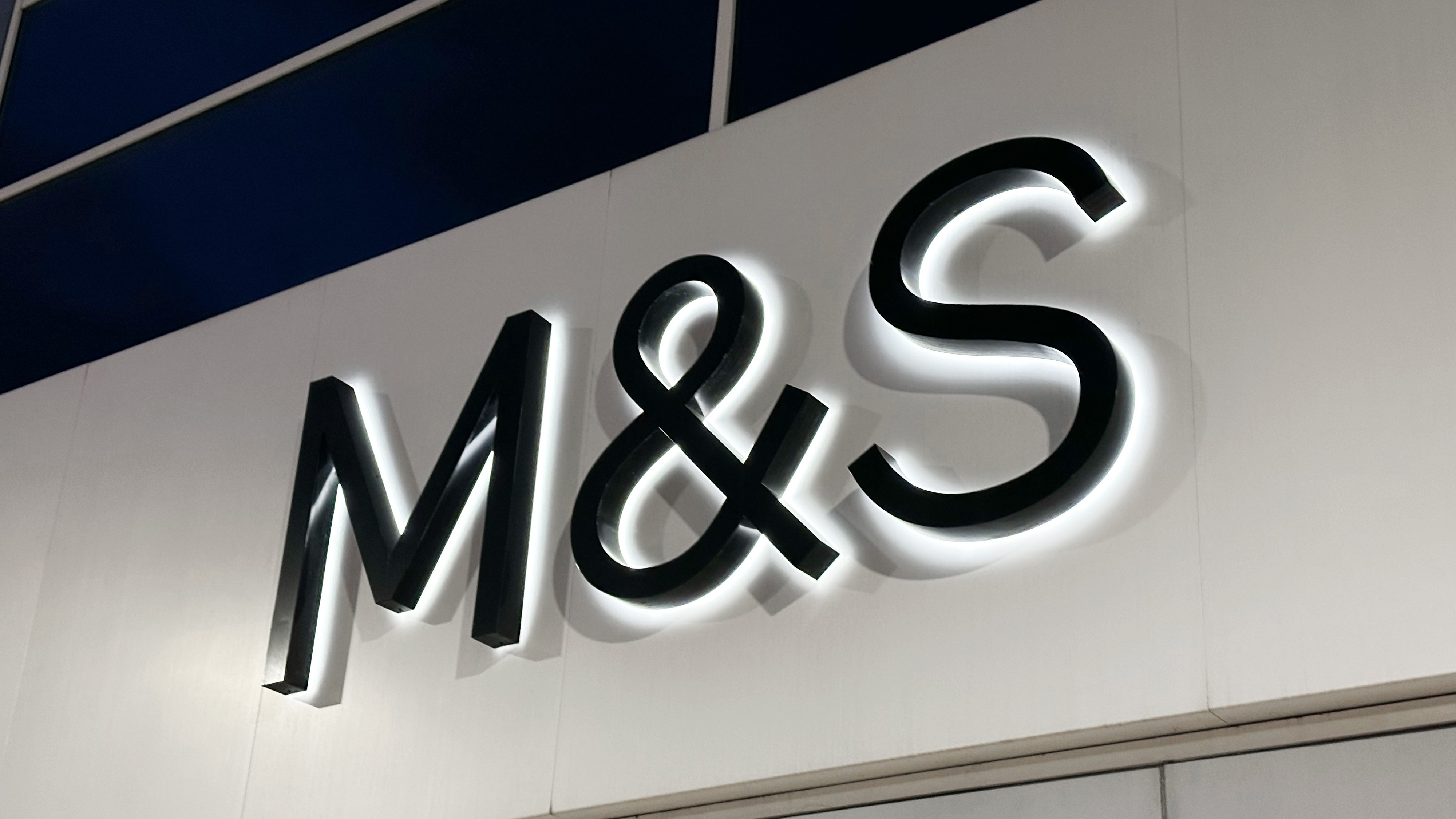 The M&S logo on the wall above a store entrance.