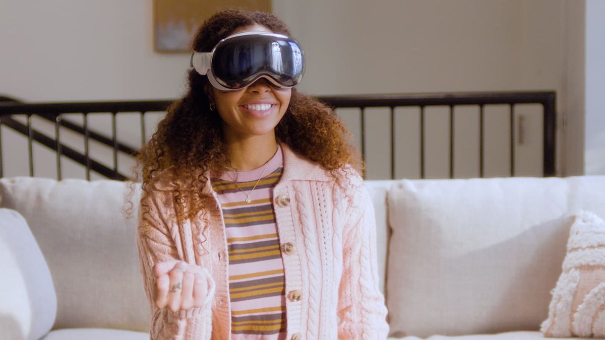 A smiling woman wearing an Apple Vision Pro