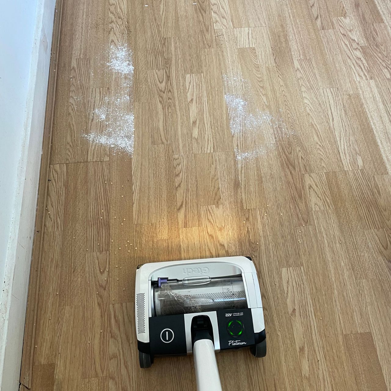 Gtech AirRAM Platinum vacuum on hardwood floor next to cous cous, flour and sugar, and coffee grounds