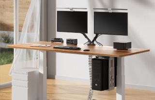 A close-up of a Sanodesk digital control panel with a glowing height display of 86.2 and various touch-sensitive buttons for adjusting a standing desk.