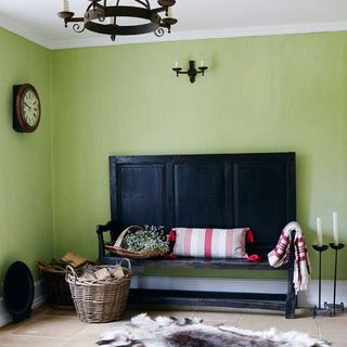 hallway with green wall and black bench and rug