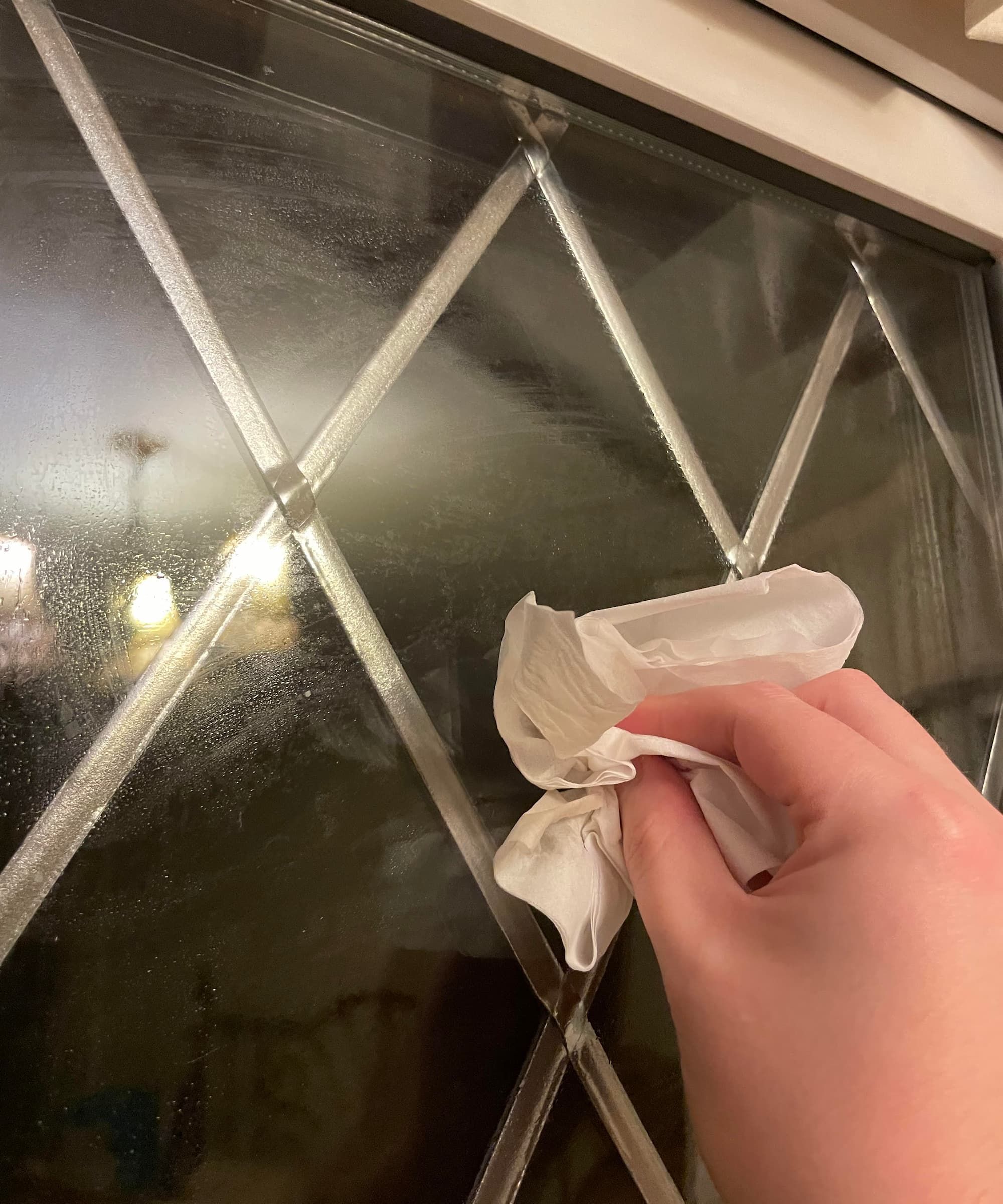 Vinegar on a tissue being wiped on a window