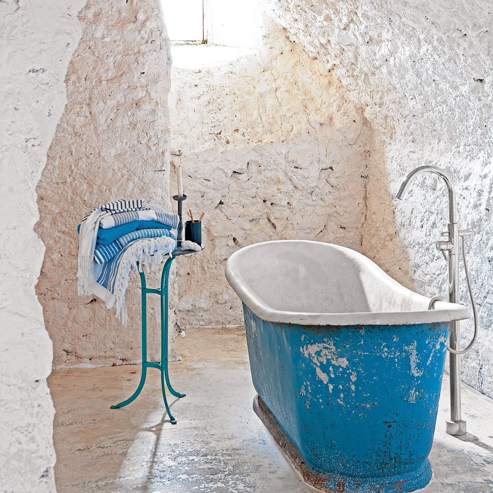 bathroom with rough white walls and bathtub