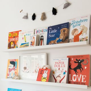 Floating shelves against a white wall displaying children's books