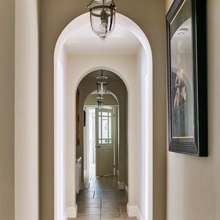 hallway with white door and pendant lights