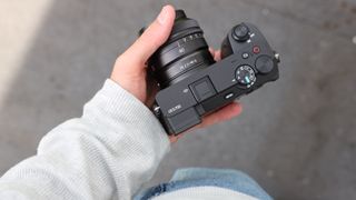Sony a6700 digital camera being held in one hand