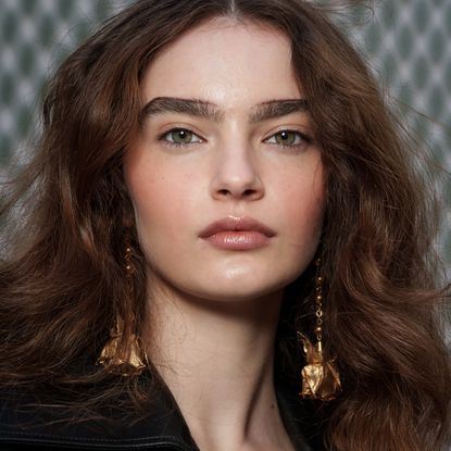 A model with impressive thick eyebrows thanks to microblading.