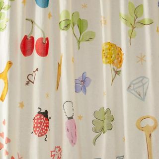A shower curtain with ladybirds, flowers, and fruits on it