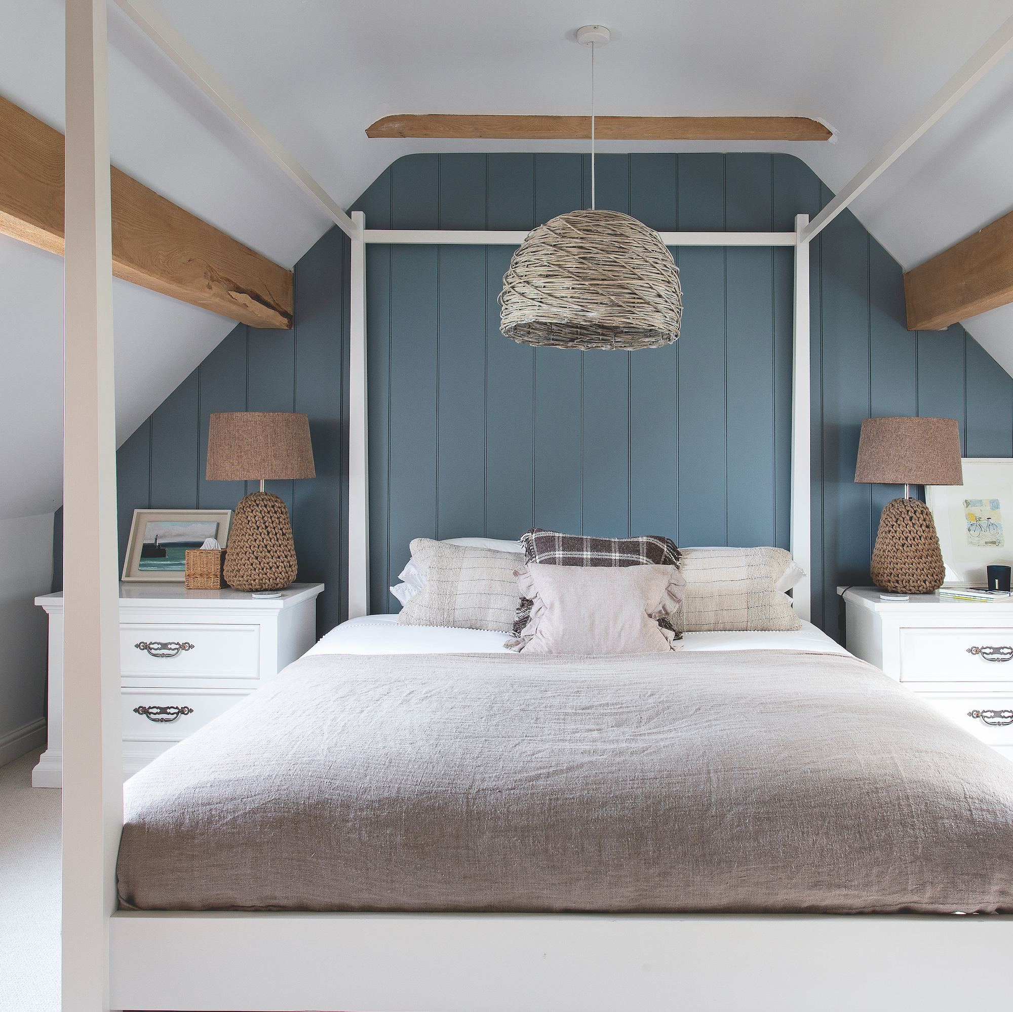 bedroom with blue painted panel wall behind bed and white four poster bed
