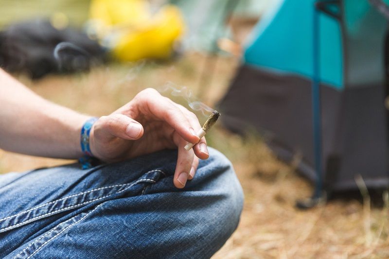 A person smoking marijuana outdoors.