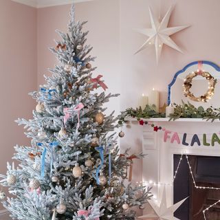 pink living room with christmas tree and wreath