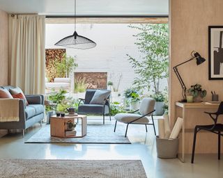 An open-plan living room by John Lewis with peachy concrete wall decor with view of exterior space