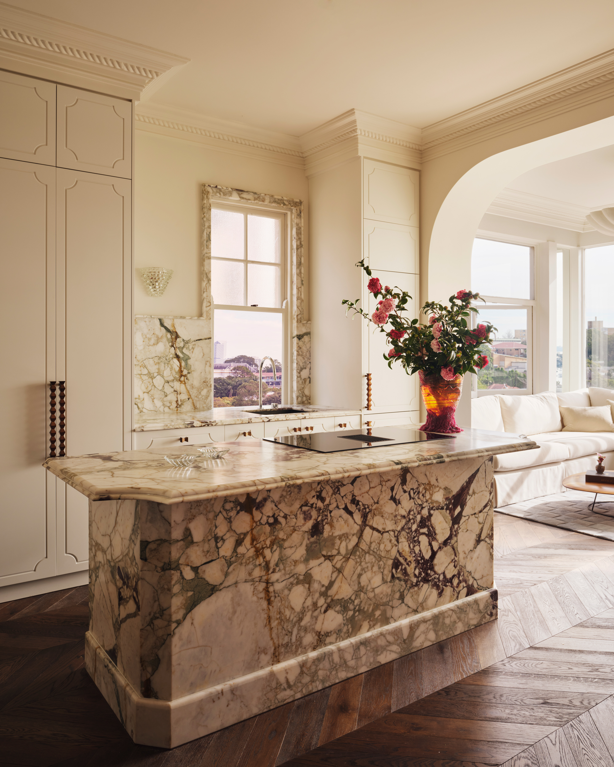 fully marble kitchen island in a small, white kitchen