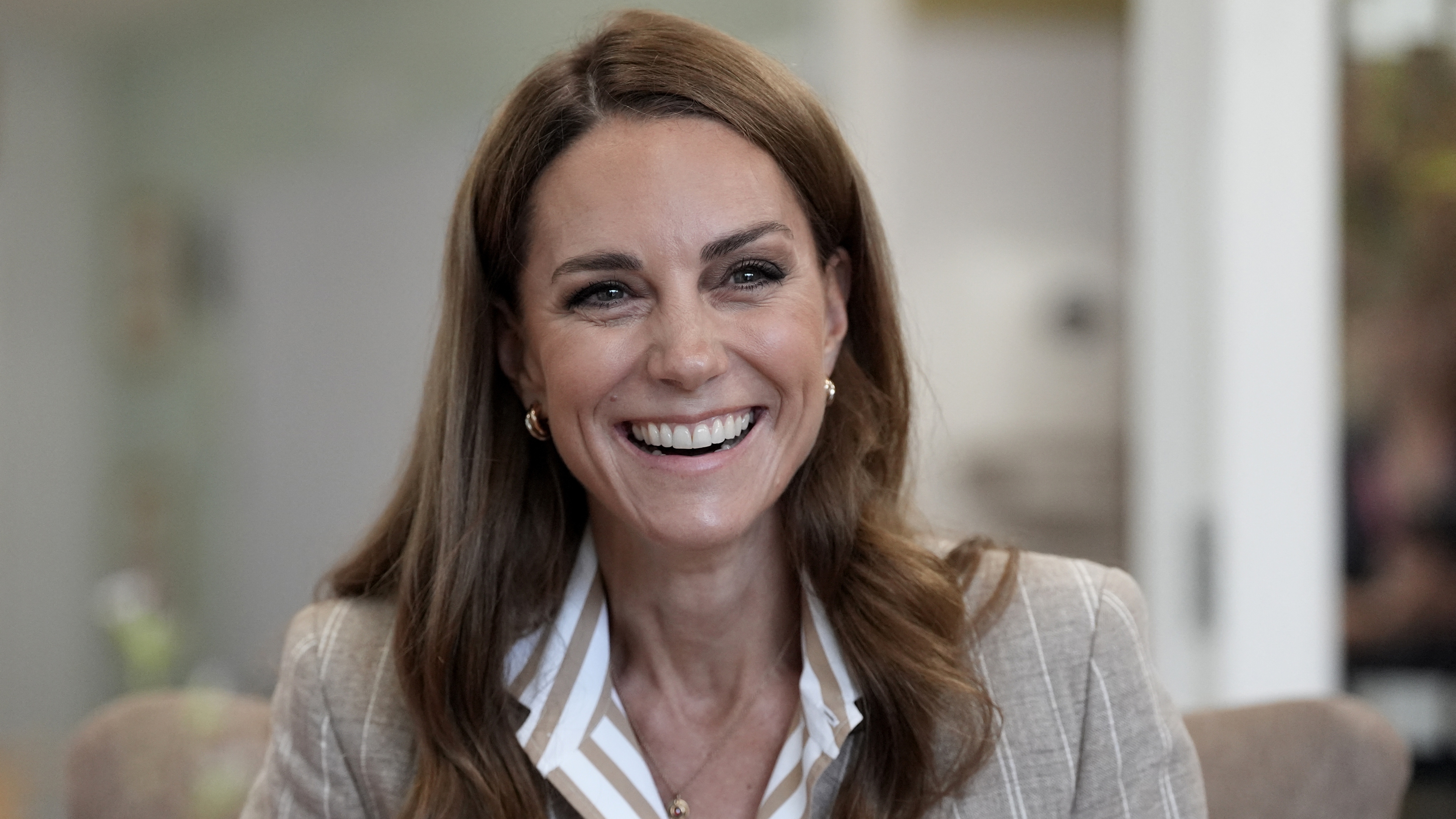 Catherine, Princess of Wales, wearing a taupe striped shirt and blazer, smiles during a visit to see the RHS Wellbeing Garden at Colchester Hospital in Essex, southeast England on July 2, 2025