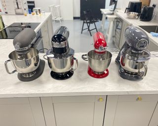 Image of KitchenAid mixer side by side next to three other mixers to show comparison during testing