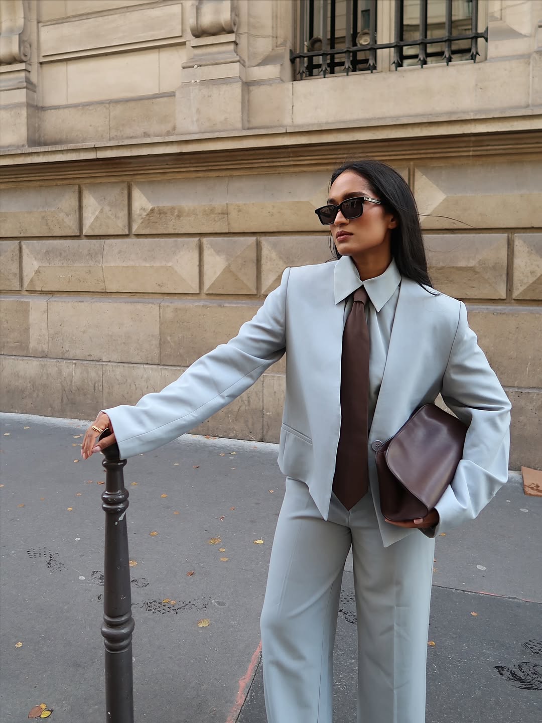 Div in a light blue suit and brown tie