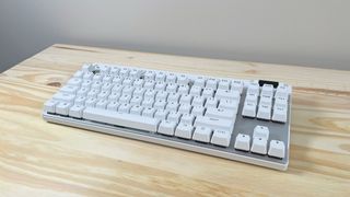 The Logitech G PRO X TKL Rapid gaming keyboard in white on a wood table