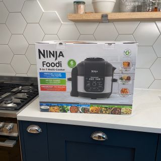 Ninja Foodi 9-in-1 Multi-Cooker in box on white kitchen counter