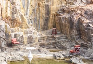 outdoor chairs and tables on rocks, photographed by Massimo Vitali for Wallpaper*