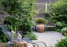 Outdoor terrace with metal benches and oversized terracotta pot