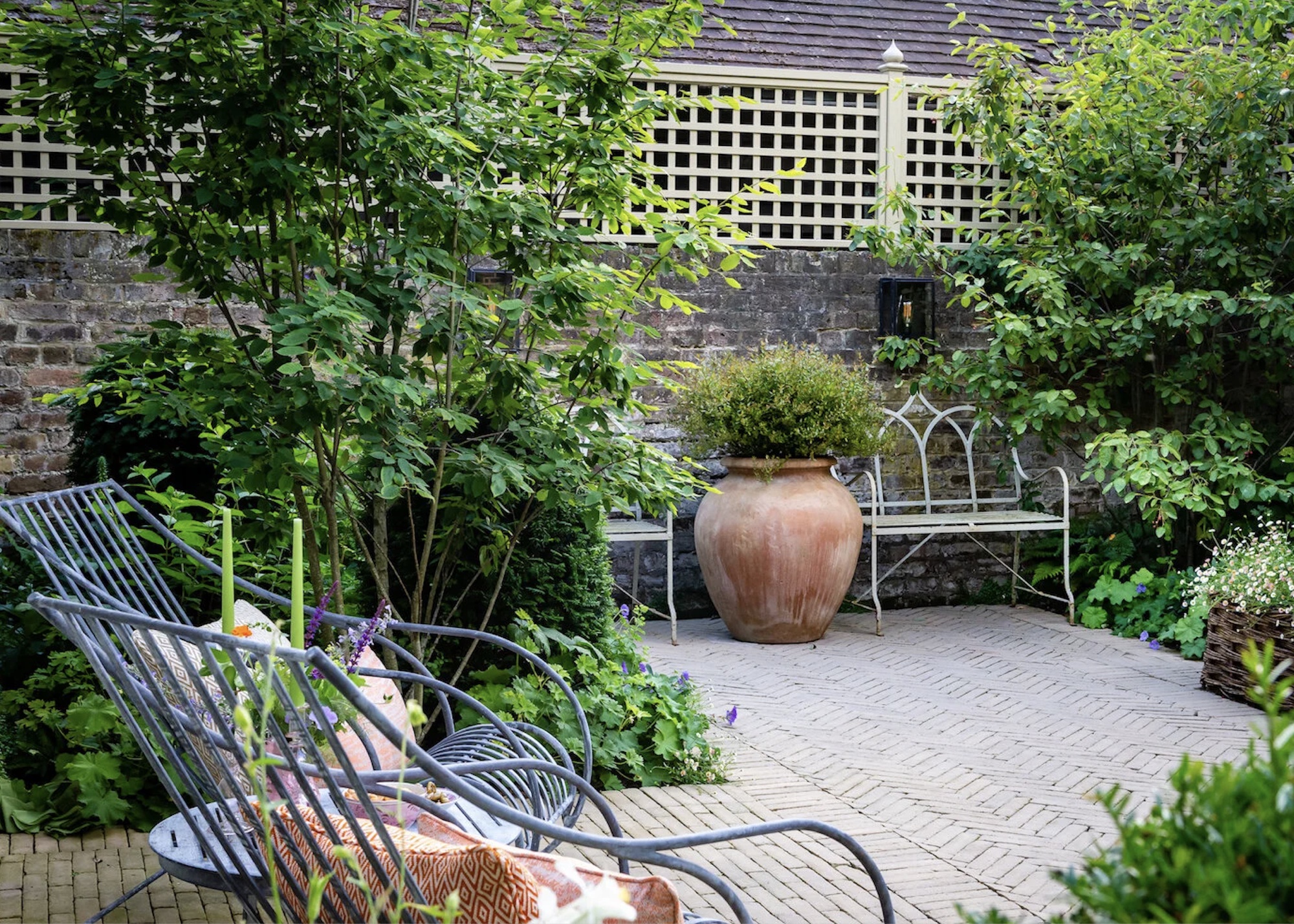 Outdoor terrace with metal benches and oversized terracotta pot