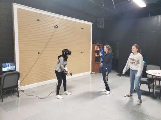 Three students sharing VR gear