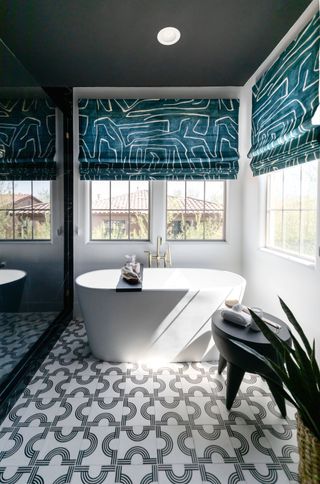 A bathroom with patterned flooring and printed blinds
