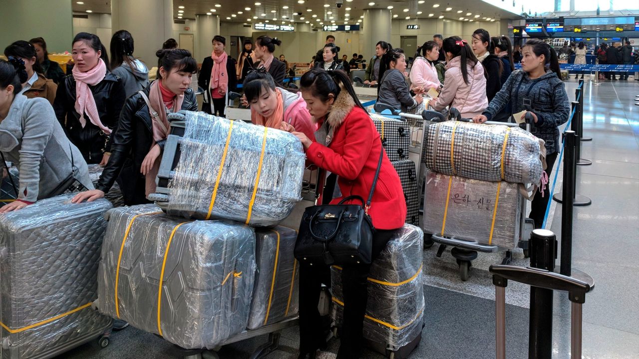 North Korean workers lining up for a flight to Pyongyang at an airport in Beijing