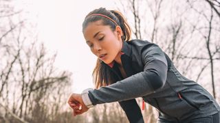 Woman checking her running watch during a training session