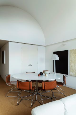 Dining room with white table, brown chairs and white walls in Barbican apartment