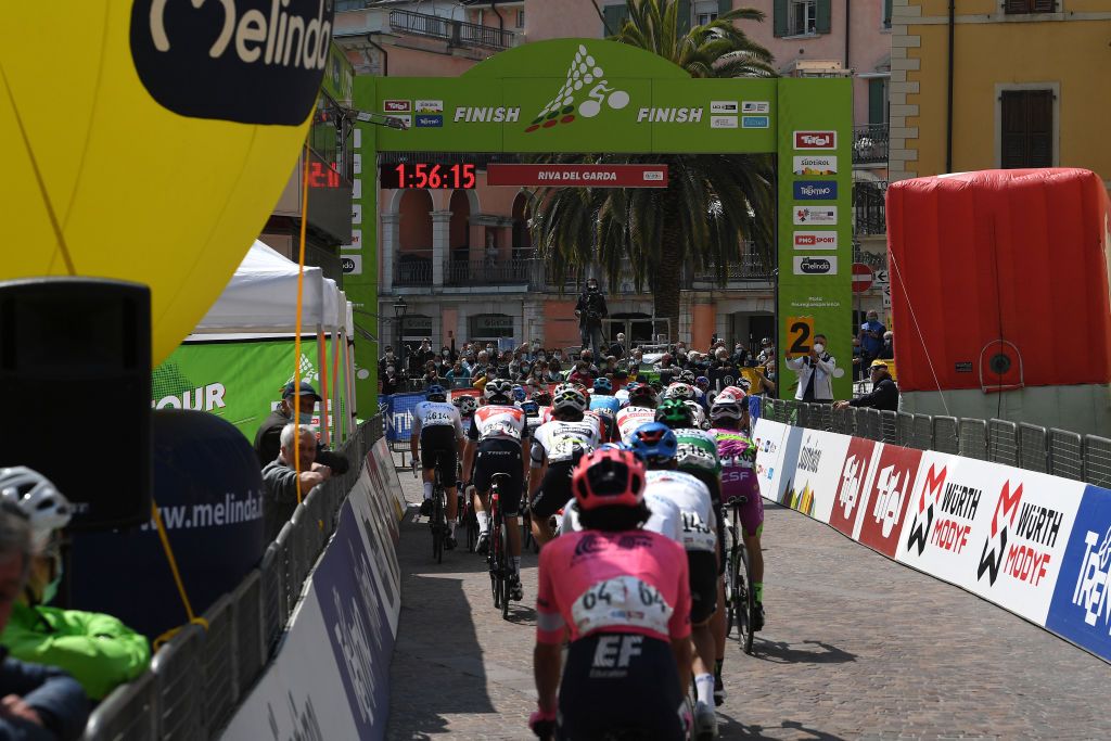 RIVA DEL GARDA ITALY APRIL 23 The Peloton passing through Riva del Garda Village during the 44th Tour of the Alps 2021 Stage 5 a 1209km stage from Valle del Chiese Idroland to Riva del Garda Church Landscape Fans Public TourofTheAlps TouroftheAlps on April 23 2021 in Riva del Garda Italy Photo by Tim de WaeleGetty Images