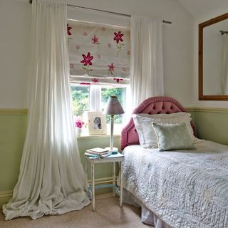 Green and white guest bedroom with floral blind