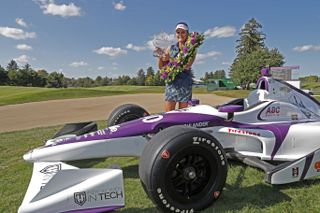Lexi Thompson poses with the trophy wearing an Indy 500 winners wreath and posing next to an Indy Car