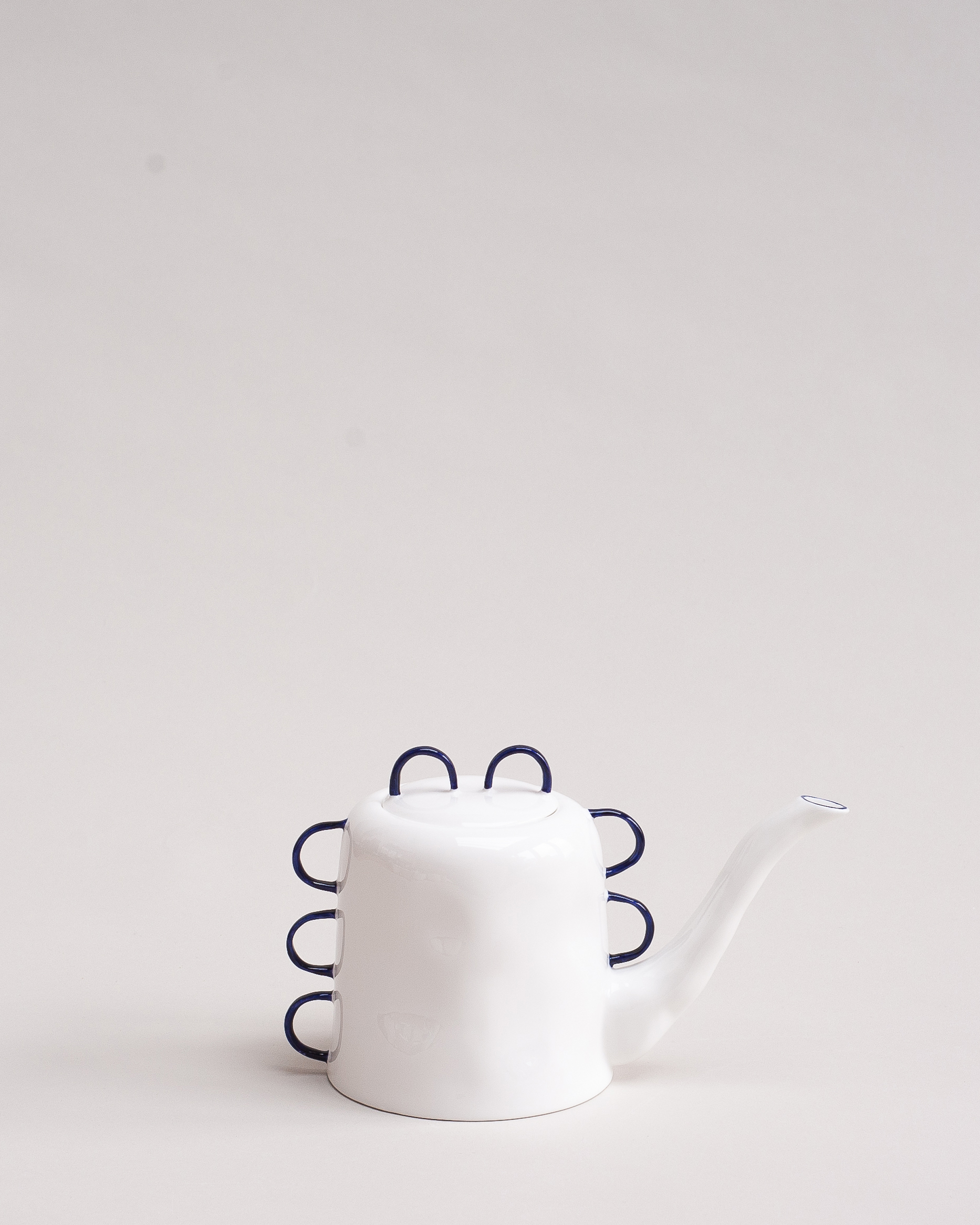 White bone china teapot with cobalt blue-painted handles and spouts