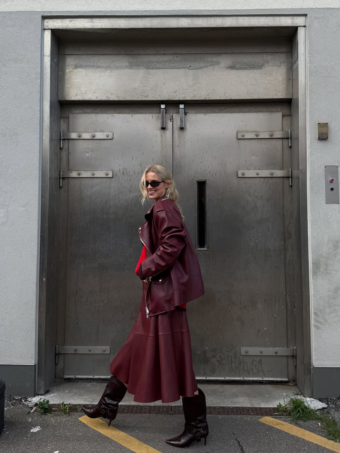 Influencer Andrea Steen wearing a red a-line skirt, red biker jacket and kitten heel boots.