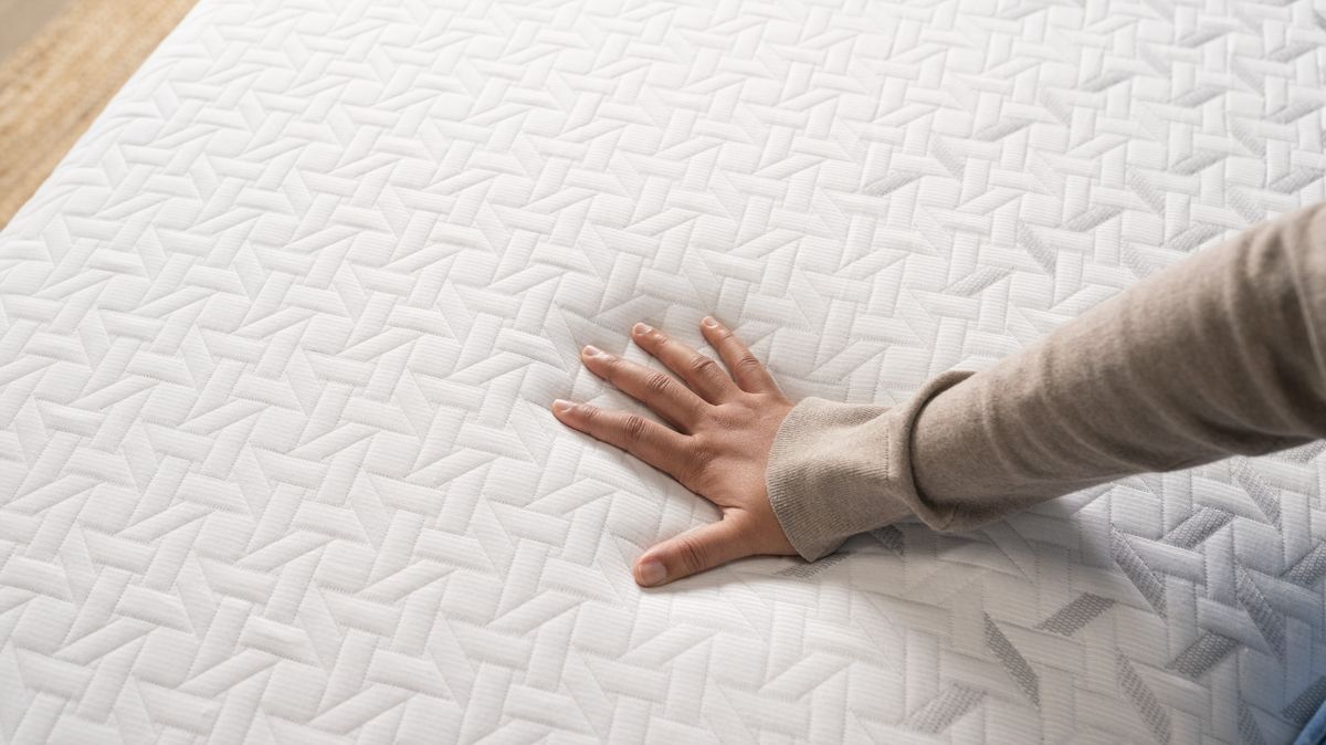 Our tester places her hand on the surface of the Nectar Premier Memory Foam Mattress to test its temperature