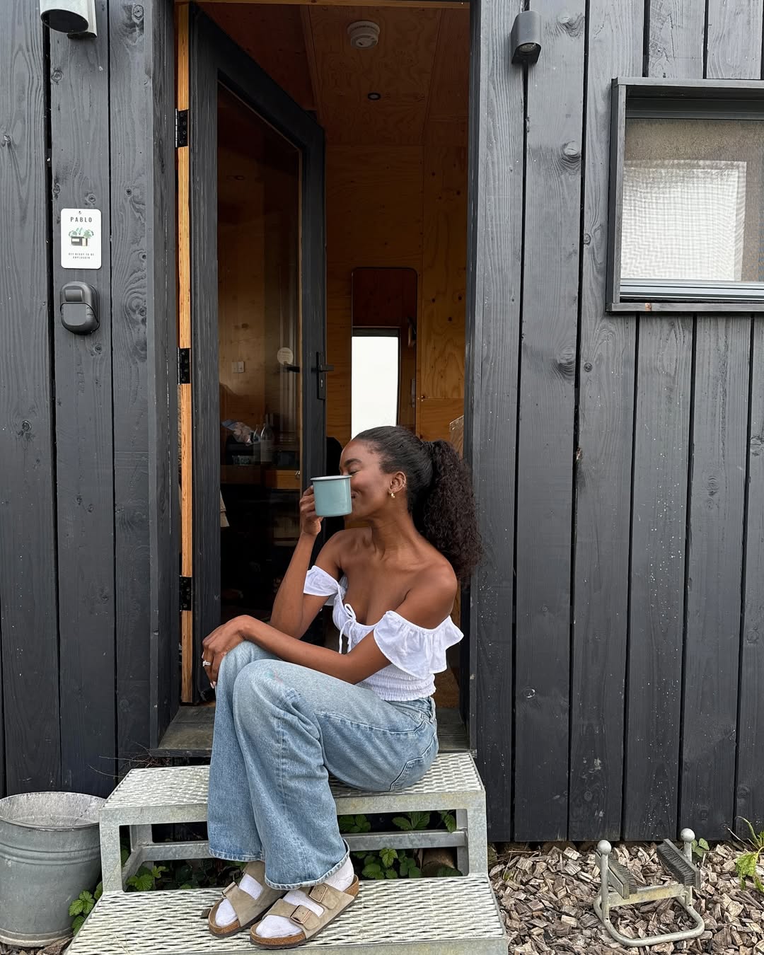 Liv in off-the-shoulder top, jeans and Birk sandals