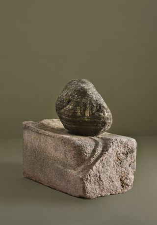 Rounded stone sitting on top of a rectangular stone