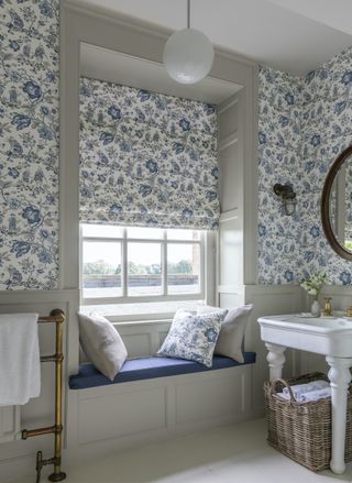 country bathroom with blue and white blind and wallpaper