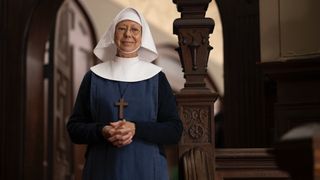 Jenny Agutter stands on the stairs of Nonnatus House in a nun's habit in the Call the Midwife Christmas Special 2024.