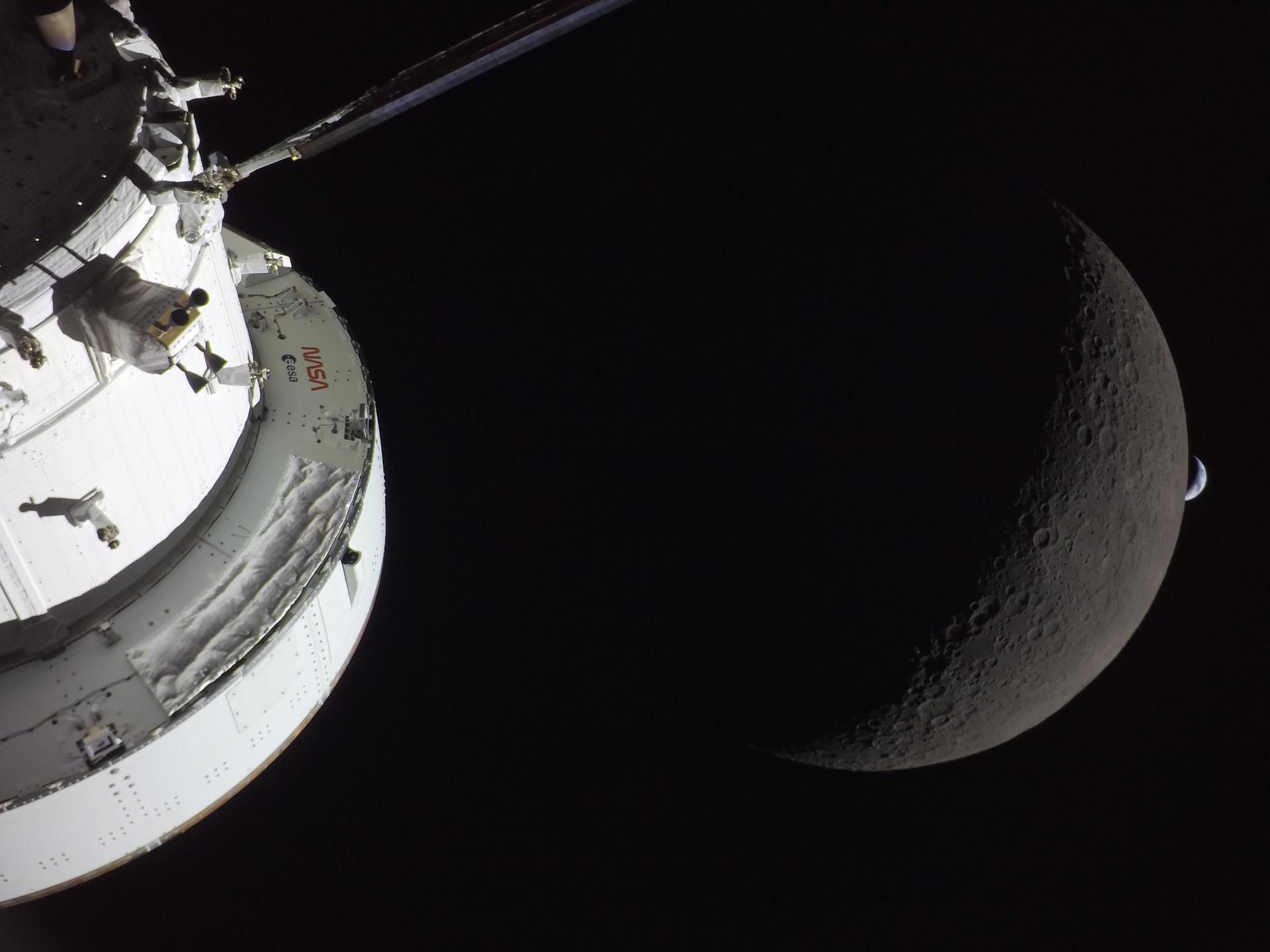 Camera on the Orion capsule (foreground) see the Earth setting behind the moon