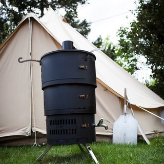black outdoor oven with white tent in grass field