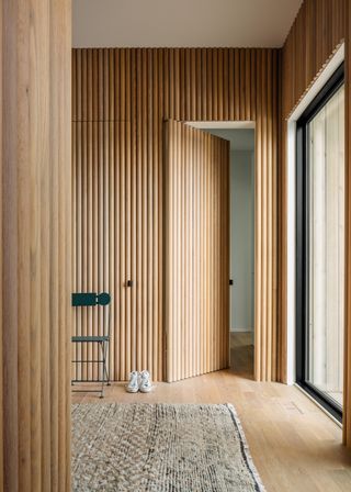 a hallway with doors hidden in fluted millwork