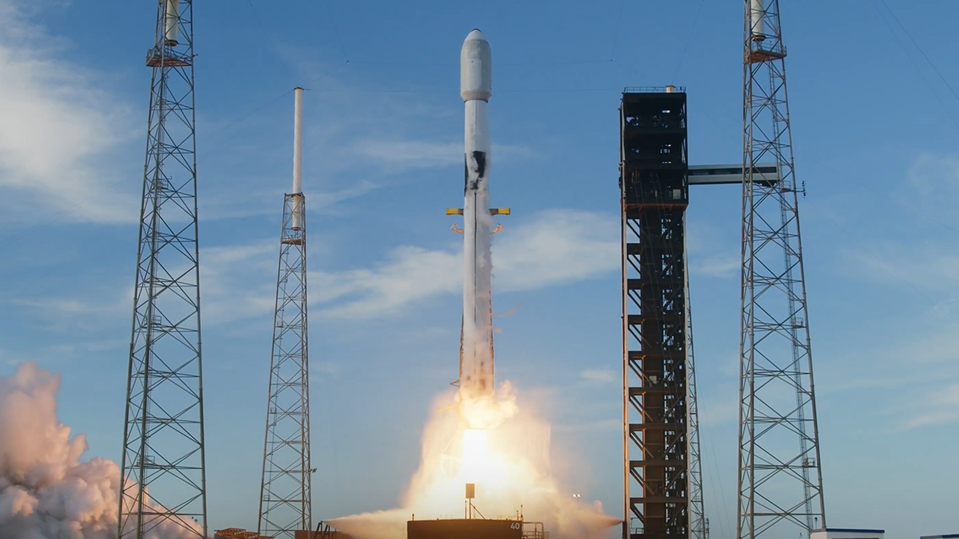 a white rocket lifts off above a plume of fire and smoke