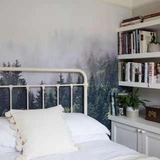 Bedroom with forest wall mural, white hospital bed, book shelf and white bedding