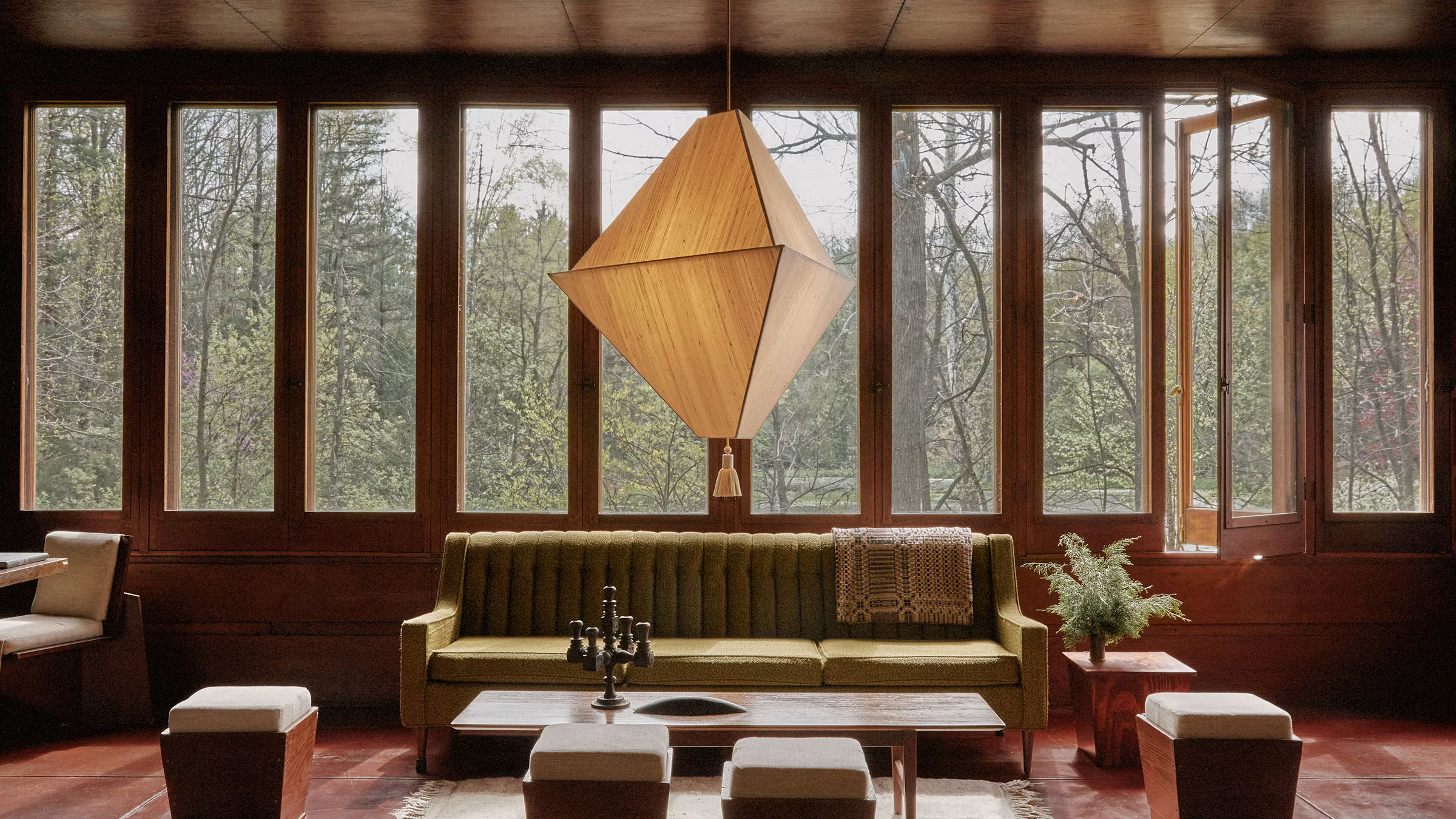 Large pyramid lantern with single tassel in wood-walled mid-century living room 