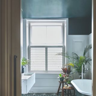 A bathroom with a contrasting blue ceiling