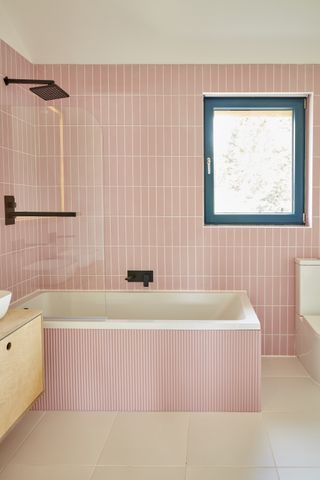 pink bathroom with tiles and bath