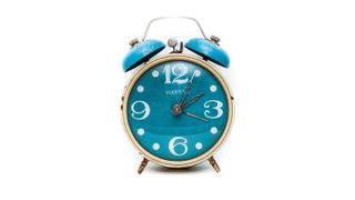 How to fall asleep faster at night: A bright blue alarm clock displaying a time of five past two